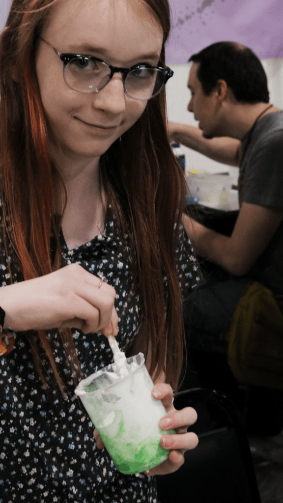 A girl mixes up an alien concoction in Pop Culture Classroom 2022 Alien Slime Lab